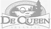 Logo of De Queen, featuring stylized text and a graphic of trees and water.